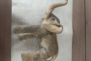 The sculpture is an antique figurine of an elephant