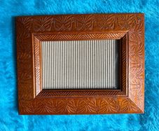 Hand-carved vintage wooden picture frame with a natural grain finish.