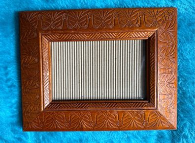 Hand-carved vintage wooden picture frame with a natural grain finish.