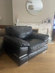 black Leather Armchair featuring plush pillow top arms and chrome accent feet need gone ASAP due to house clearance