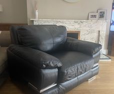 black Leather Armchair featuring plush pillow top arms and chrome accent feet need gone ASAP due to house clearance