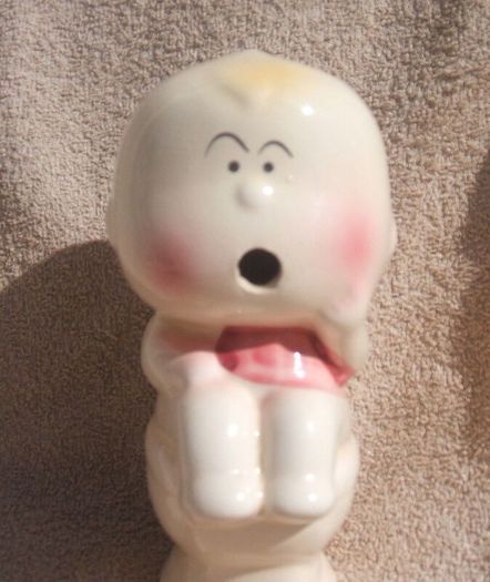 A vintage novelty money box in form of a young child sitting on a toilet (1930s to 1960s)