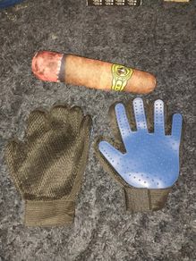 A pair of pet grooming and deshedding glove and Cigar designed toy for dogs