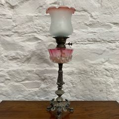 Early Edwardian oil lamp with cast metal base.