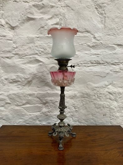 Early Edwardian oil lamp with cast metal base.