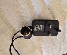 AC/DC power adapter (Model: 1220) that converts household AC mains power (100-240V) into a 12V DC cigarette  lighter socket.