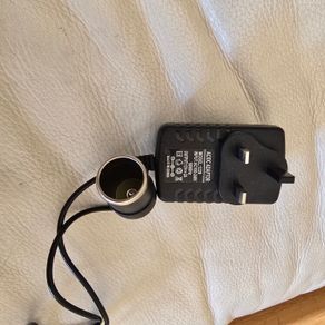 AC/DC power adapter (Model: 1220) that converts household AC mains power (100-240V) into a 12V DC cigarette  lighter socket.