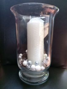 tall clear vase with white candle and decorations