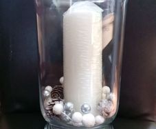 tall clear vase with white candle and decorations