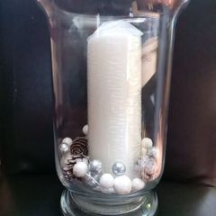 tall clear vase with white candle and decorations