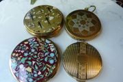 A Collection of Mid-Century Compacts. Tallent Enamel, Kigu, a Courting Couple Novelty Piece and a Henriette Pocket-Watch Compact