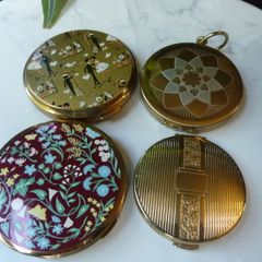 A Collection of Mid-Century Compacts. Tallent Enamel, Kigu, a Courting Couple Novelty Piece and a Henriette Pocket-Watch Compact