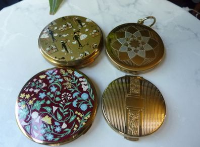 A Collection of Mid-Century Compacts. Tallent Enamel, Kigu, a Courting Couple Novelty Piece and a Henriette Pocket-Watch Compact