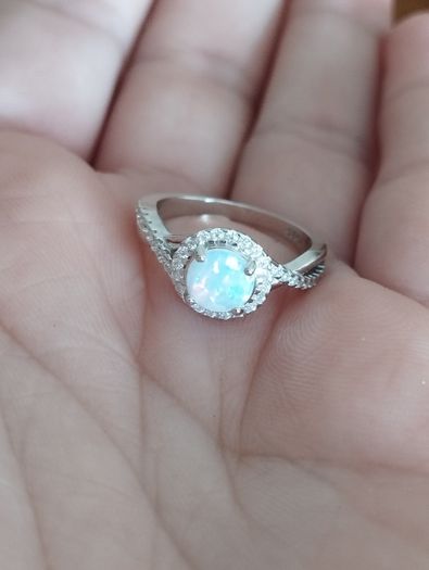 A beautiful 925 silver ring with a white lab opal surrounded by shining cubic zirconia.