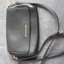 Michael Kors black crossbody bag with adjustable shoulder strap and gold-tone hardware. In great condition, only some colour fading on the logo, as shown in the photos. Image 2