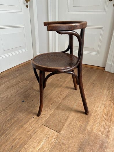 A vintage 1920s Thonet style bentwood chair with armrests.