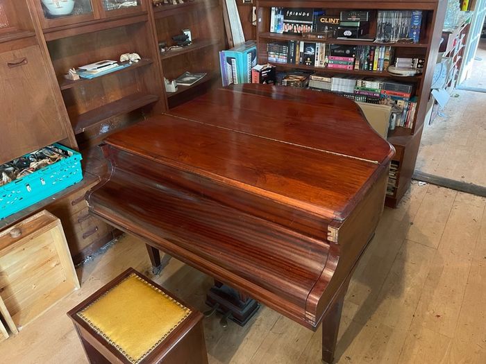 a circa-1931 Monington & Weston baby grand with matching stool.