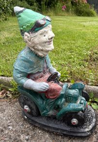 Vintage Reconstuted stone garden gnome on car, hand painted